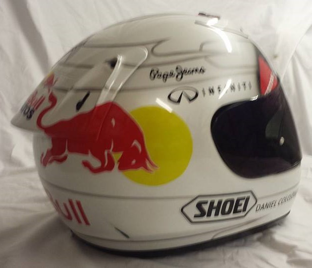 Airbrushed Painting of a White Custom Helmet with Red Bull design close up of Red Bull logo